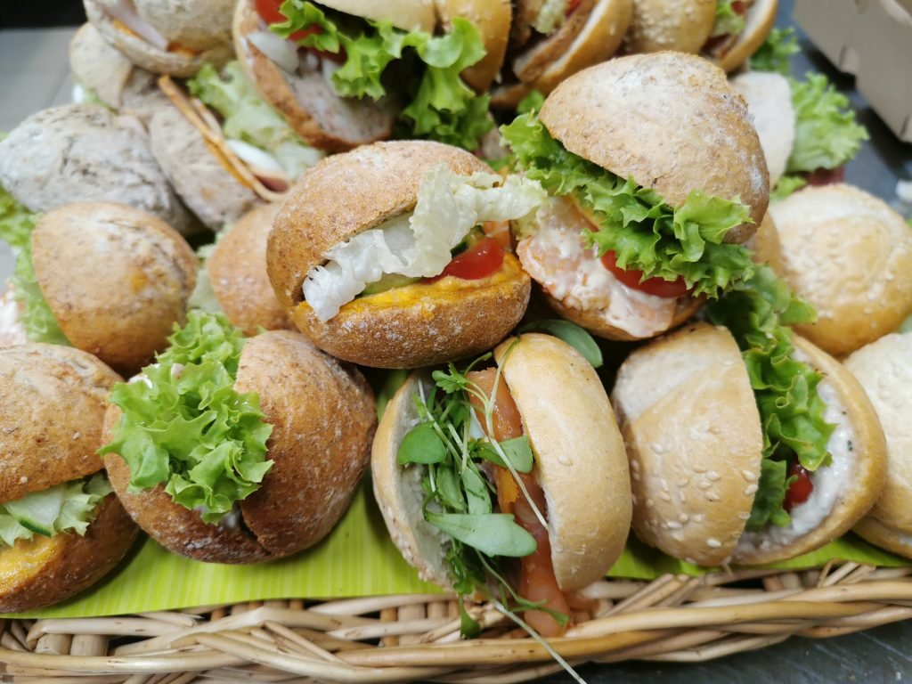 Mand met vers belegde mini broodjes